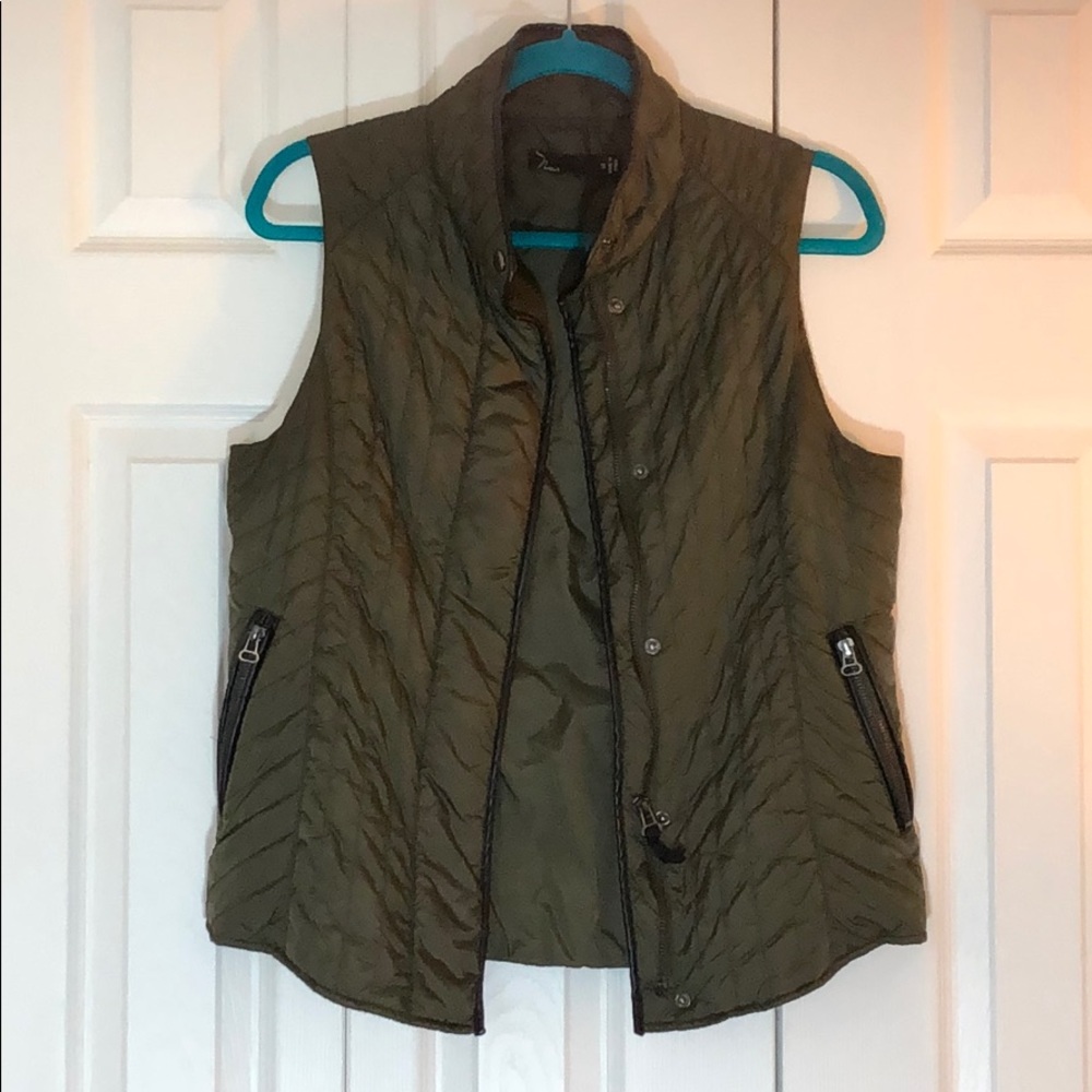 olive green vest, black leather details